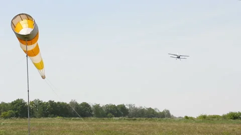 Light single-engine aircraft lands on the field airfield. The aircraft sits on Stock-Footage 90360630