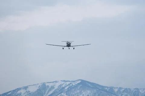 Light single-engine airplane climbing over snow-capped mountains Stock-Fotos