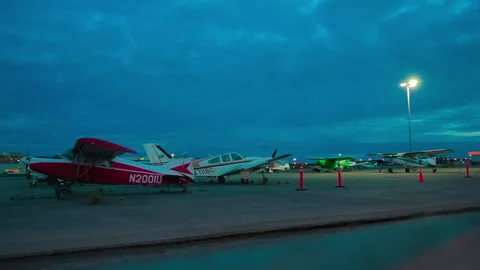 Light single-engine planes and car parked the night at the Alaska airport Stock Footage 139770194