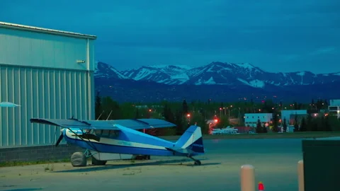 Light single-engine planes and car parked the night at the Alaska airport Stock Footage 139770214