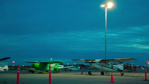 Light single-engine planes and car parked the night at the Alaska airport Stock Footage 139770237