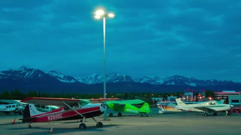 Light single-engine planes and car parked the night at the Alaska airport Stock Footage 139770272