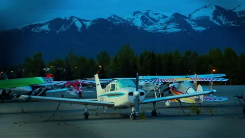 Light single-engine planes and car parked the night at the Alaska airport Stock Footage 139770305