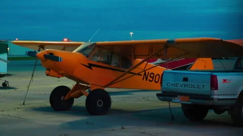 Light single-engine planes and car parked the night at the Alaska airport Stock Footage 139770344