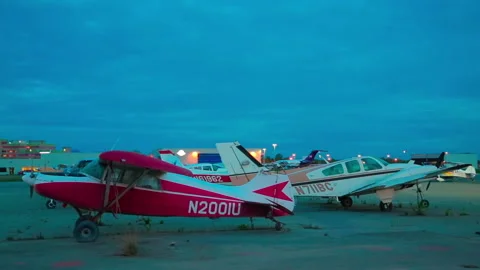 Light single-engine planes and car parked the night at the Alaska airport Stock Footage 139770364