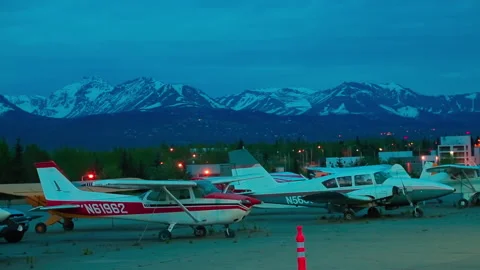 Light single-engine planes and car parked the night at the Alaska airport Stock Footage 139770474