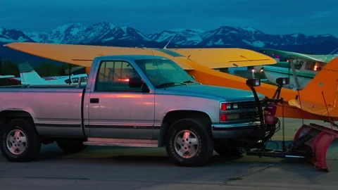 Light single-engine planes and car parked the night at the Alaska airport Stock Footage 139770568