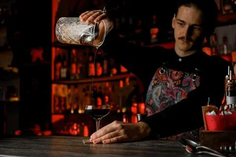 Light-skinned guy with black short hair and a neat mustache mixing cocktail Photos