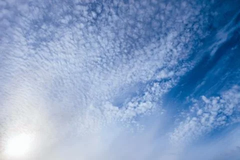 Light small cirrocumulus clouds on a bright sunny blue sky Stock Photos