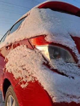 Light snow covers the rear of the red car Stock Photos