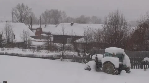 Light snow is falling against the background of already snow-covered wooden vill Stock Footage 147078363