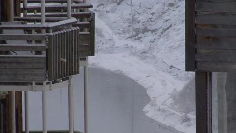 Light snow falling on buildings and lake Stock Footage 303588903