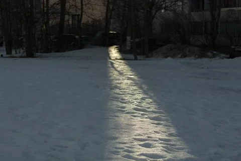 Light in the snow. The setting sun shines in winter on the snow-covered surfa Stock Photos