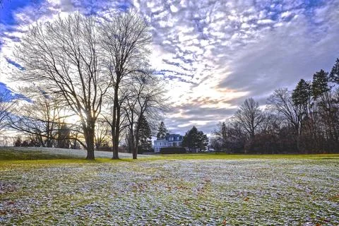 Light snowfall in springtime in the backyard of a mansion. Stock Photos