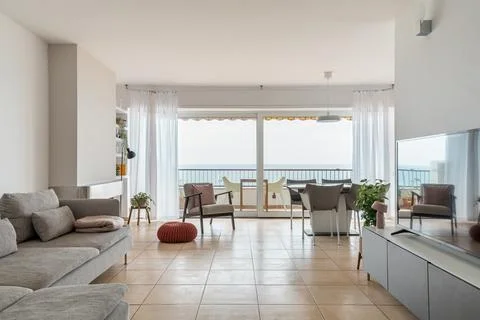 Light spacious living room with large balcony at seaside Stock Photos