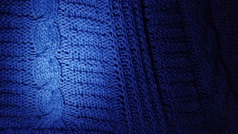 Light spot slowly moving left to right over dark blue knitted wool background Stock Footage 146158687
