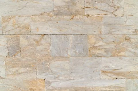 Light stone wall with warm veining and rectangular masonry layout Stock Photos
