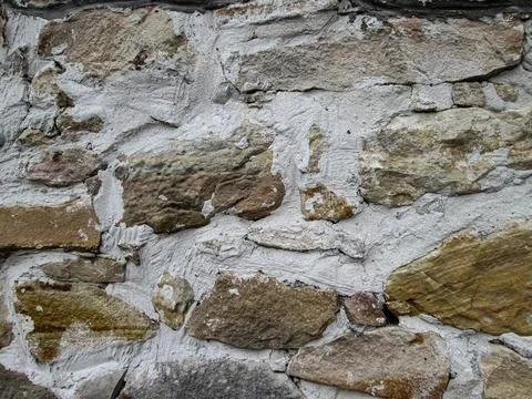 Light stones embedded in concrete. The texture of a solid medieval structure. Stock Photos