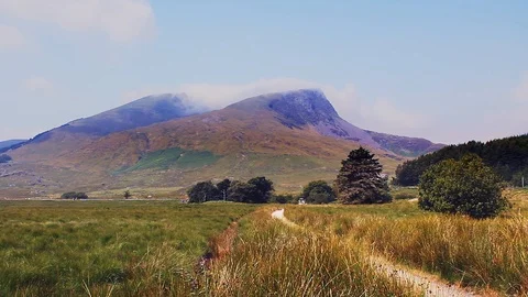 Light summer clouds over Mynydd Drws Y coed and Y Garn from Rhyd Ddu. Stock Footage 114962186
