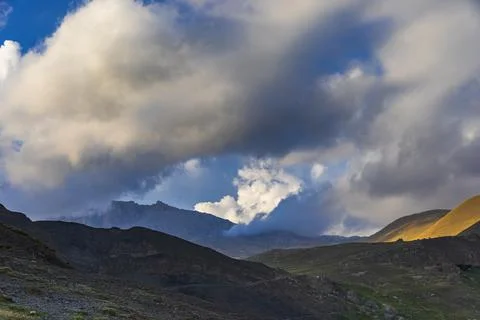 Light from the sun making its way through the clouds to the mountains Stock Photos