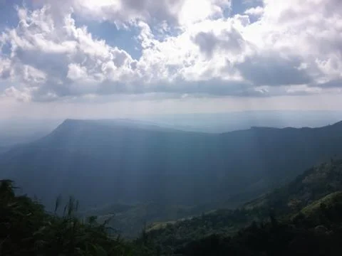 Light from the sun through the clouds into the mountains. Stock Photos