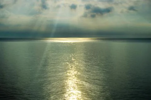 The light of the sun through the clouds, over the sea Stock Photos