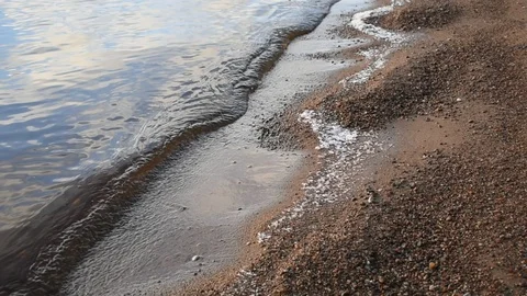 Light surf, sandy shore with remnants of ice Stock Footage 122734590