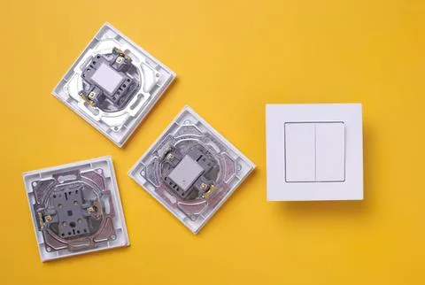 Light switch and electrical outlets on yellow wall Stock Photos