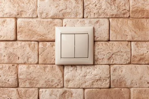 Light switch on a beige brick wall. Foto stock