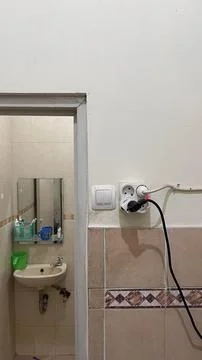 Light switch button, power plug and socket stuck to the wall. Stock Photos