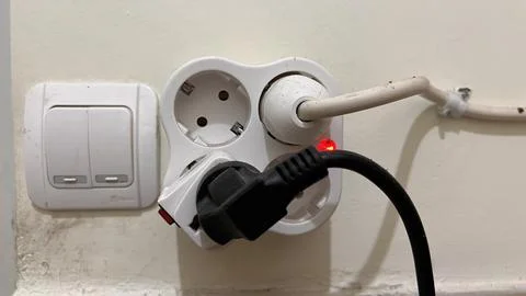 Light switch button, power plug and socket stuck to the wall. Stock Photos
