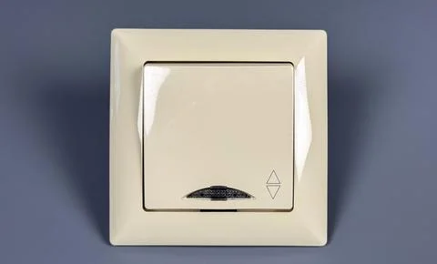 Light switch on a gray wall in a home setting Stock Photos