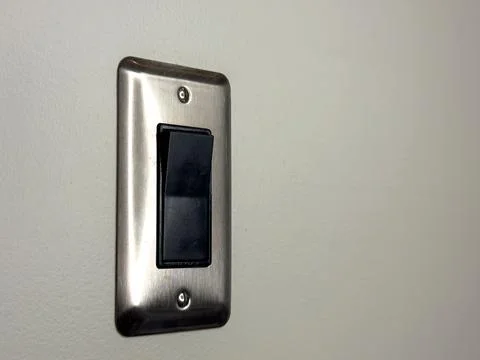Light switch mounted on a wall in a room with neutral color Stock Photos