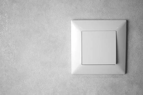 A light switch, a plastic mechanical switch of white color installed on a lig 스톡 사진