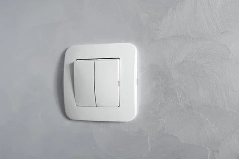 Light switch, a plastic mechanical switch of white color installed on a light Stock Photos
