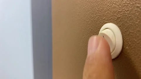 Light switch power on and off toggle close up view on brown wall Stock Footage 249873398