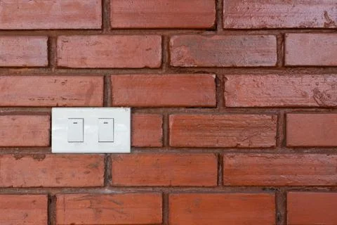 Light switch on red brick wall Stock Photos