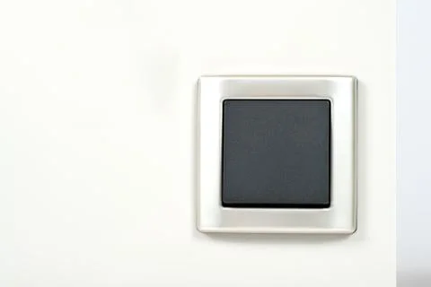 Light switch with silver frame on the wall Stock Photos