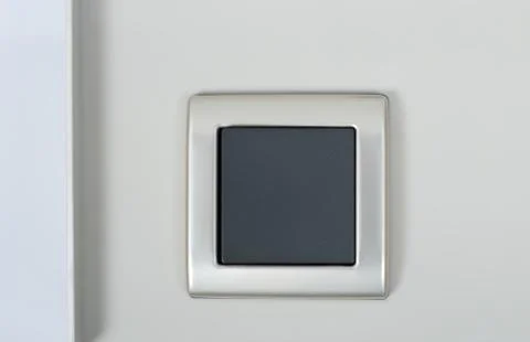 Light switch on the wall with grey button on silver frame Stock Photos
