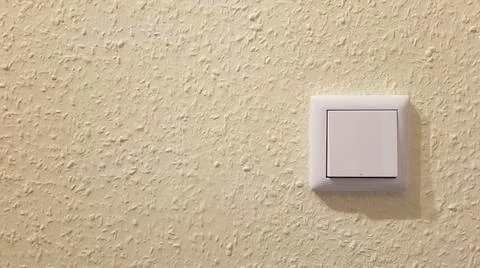 Light switch on the wall on yellow background Stock Photos