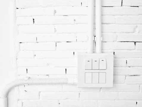Light switch on white brick wall Stock Photos