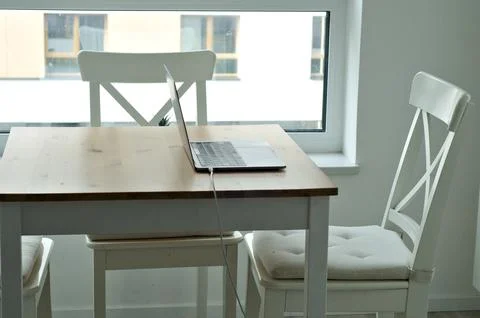 Light table with chairs with laptop. workspace on kitchen table Stock Photos