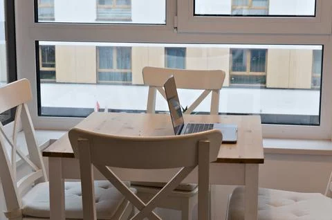 Light table with chairs with laptop. workspace on kitchen table Stock Photos