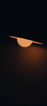 Light from table desk lamp shines on the wall in a dark room. Stock Photos