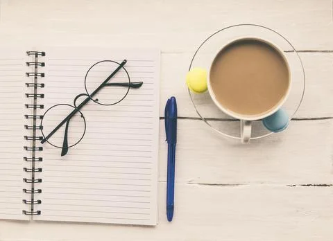 Light texture in white and blue colors: glasses, a notebook, pen and a cup of Stock Photos