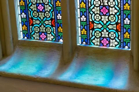 Light through colored glass in window in old church Stock Photos