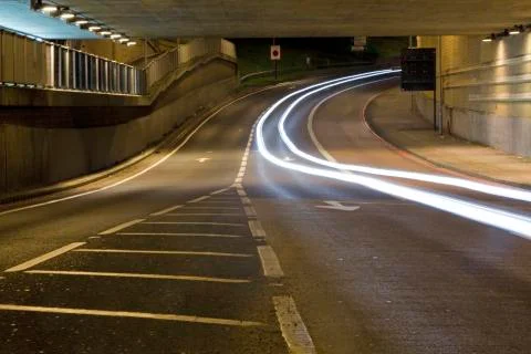 Light trail of a car driving under a subway Stock Photos