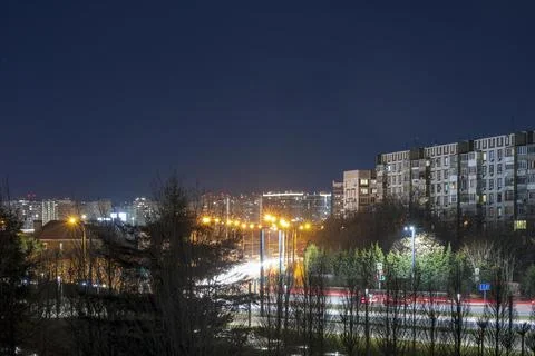 Light trails against the backdrop of a nightly luminous city. Stock Photos