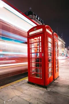 Light trails of a double decker bus next to the iconic telephone booth in London Stock Photos