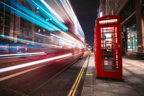 Light trails of a double decker bus next to the iconic telephone booth in London Stock Photos